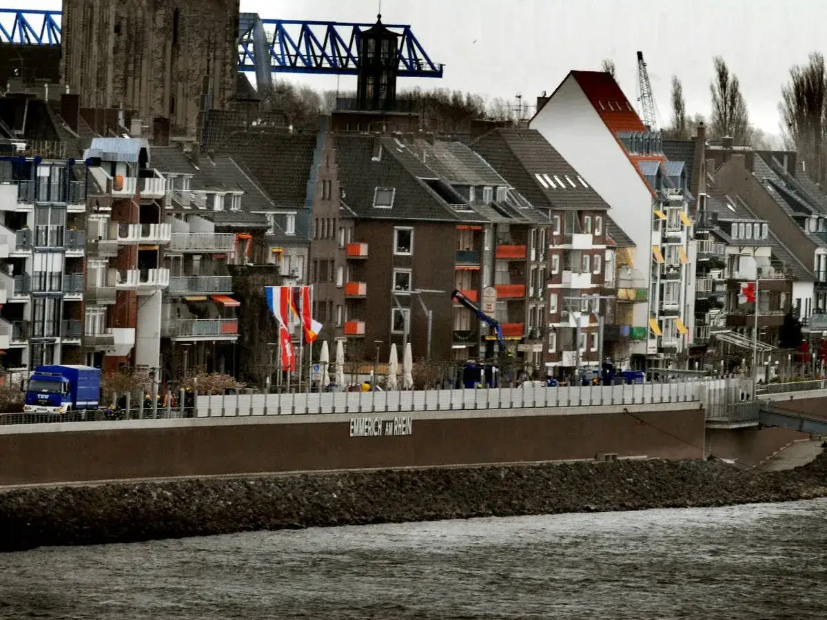 Bunte H&auml;userfront am Rhein in Emmerich Altstadt, mit Br&uuml;cke und Kran im Hintergrund.