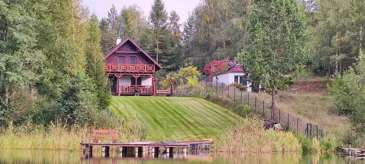 Malowniczy dom nad jeziorem sprzedam. Drewniany domek z werandą, trawnik, pomost i las. Idealne miejsce na wypoczynek.