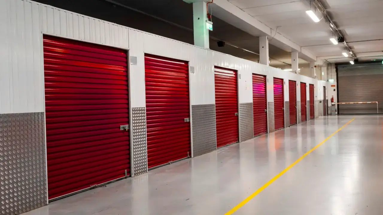 Pasillos con puertas rojas de trasteros en garaje, cumpliendo la normativa trasteros en garajes.