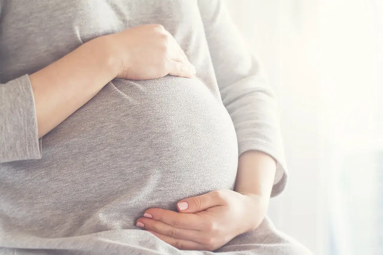 Ciepło otulony brzuch, przyszła mama delikatnie głaszcze go, myśląc o słodkim smaku miodu w ciąży.