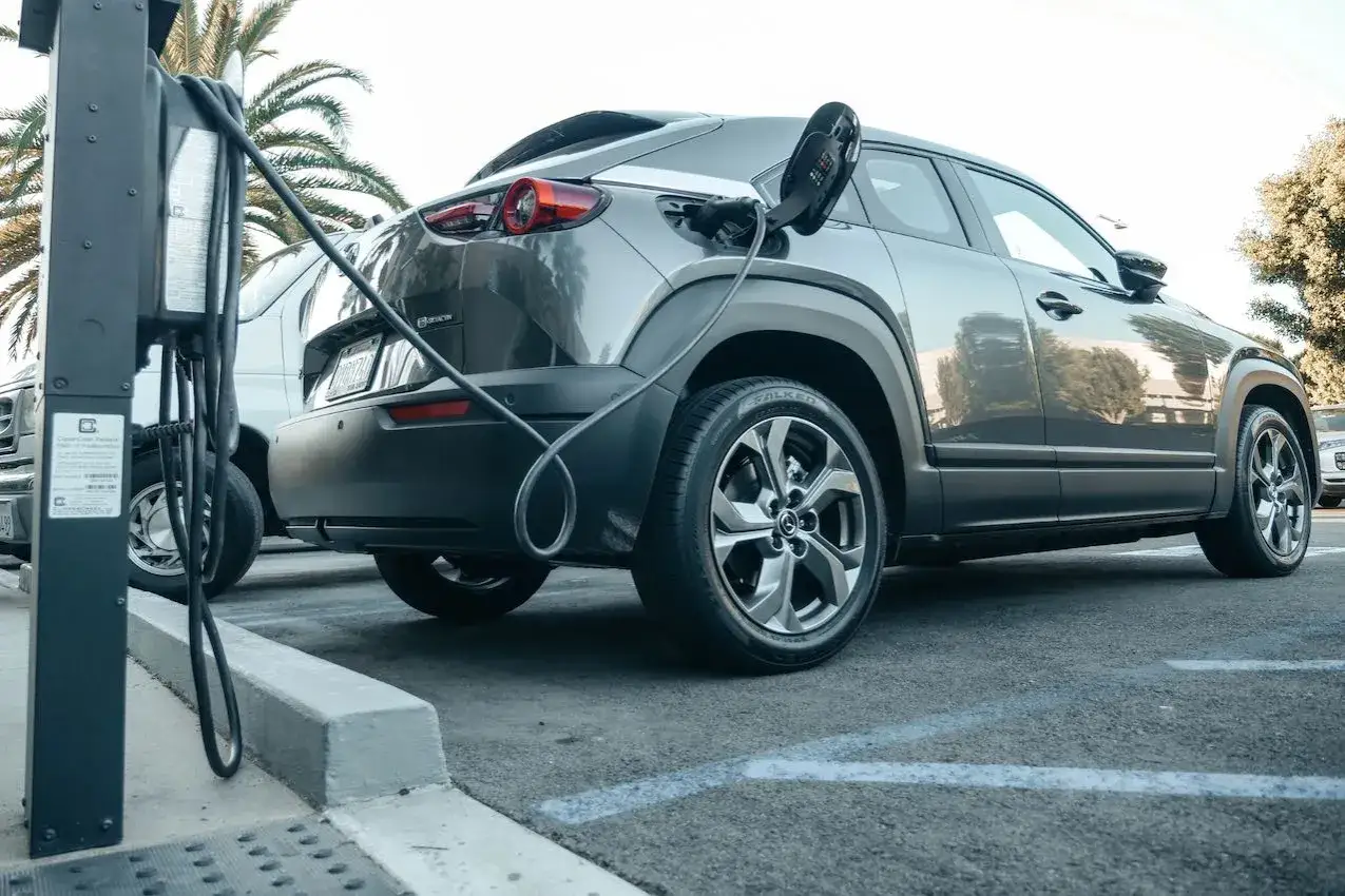 Coche el&eacute;ctrico cargando en un aparcamiento. Los hibridos pagan zona azul, pero este coche es 100% el&eacute;ctrico.