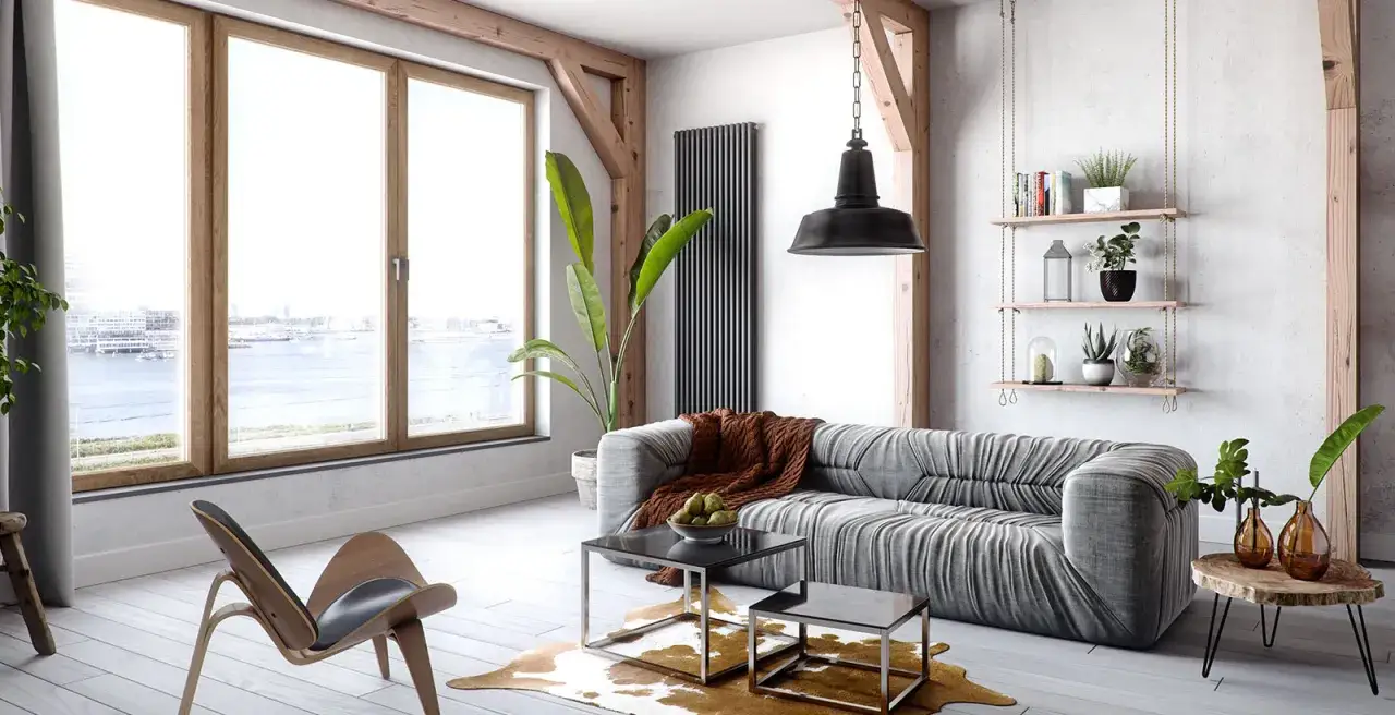 Nowoczesny salon z widokiem na wodę, okna w kolorze złoty dąb, szara kanapa i designerski fotel.