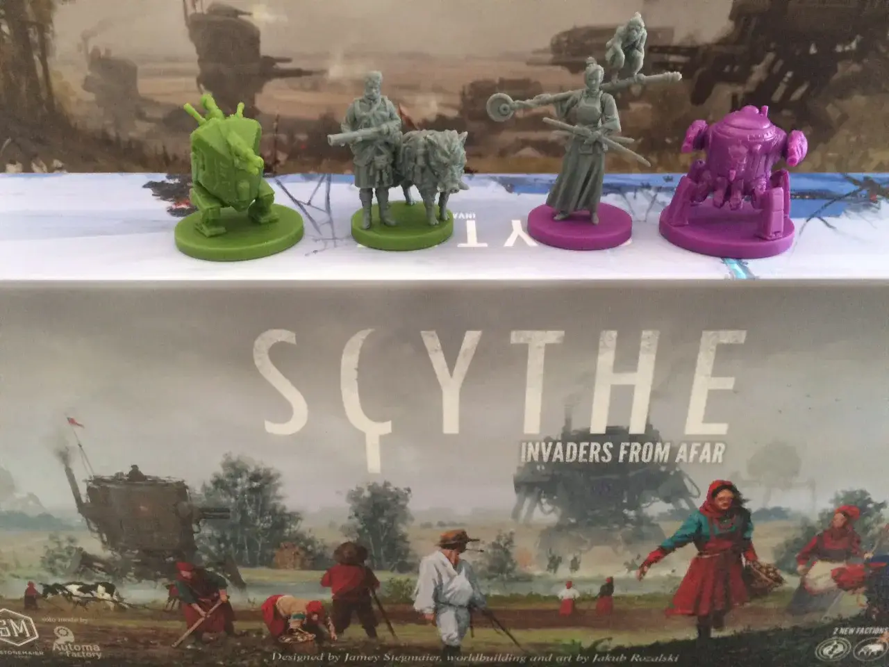 Figurki z gry Scythe Ekspedycje: zielony mech, żołnierz z dzikiem, wojowniczka z mieczami i fioletowy robot.