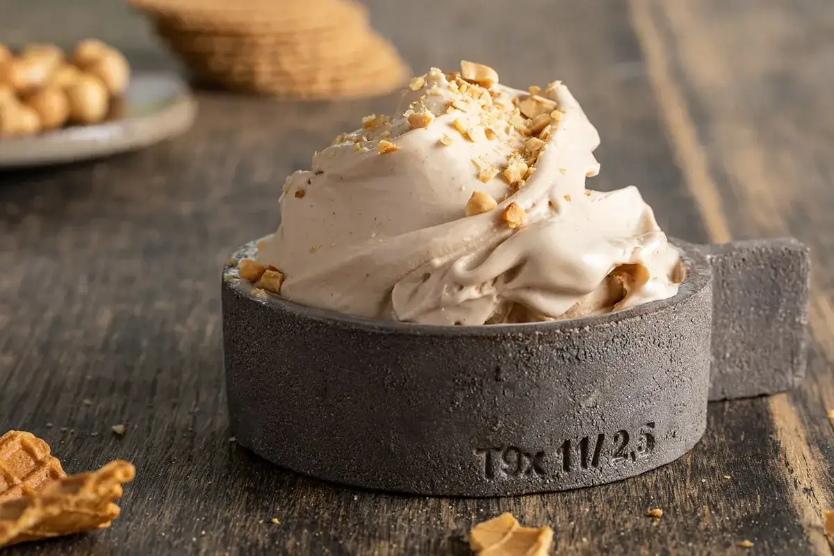 Delizioso gelato alla nocciola appena fatto con la gelatiera, guarnito con granella croccante.