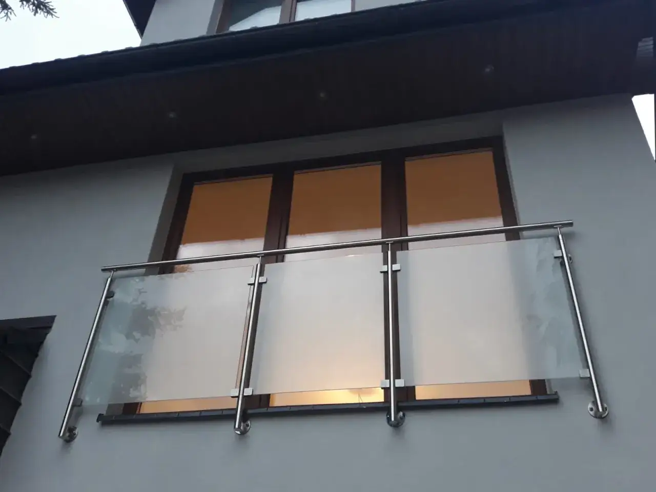 Nowoczesne balkony francuskie ze szkłem i stalą, dodające elegancji fasadzie budynku.