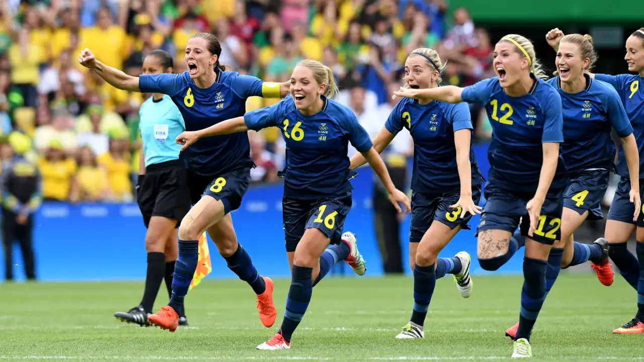 Svenska damlandslaget fotboll firar en vinst. Spelarna i blått med gula siffror springer glatt på planen.