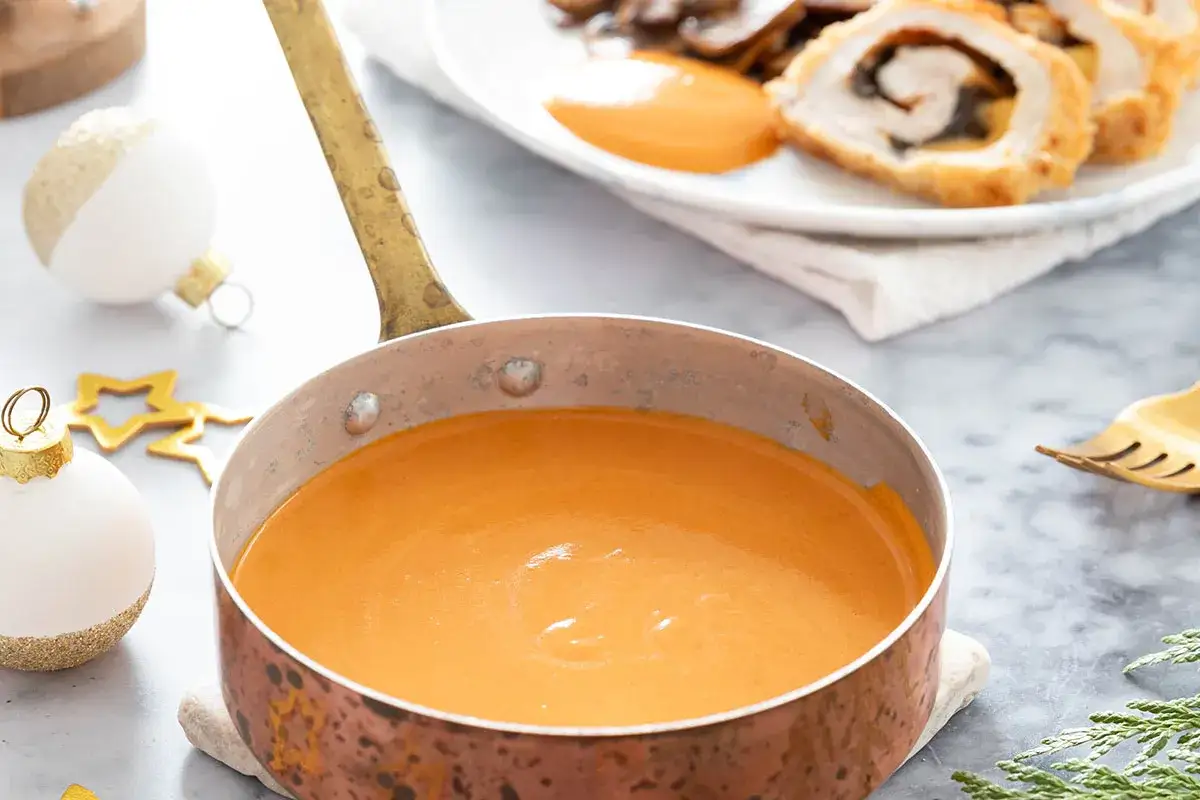 Sauce du chef onctueuse dans une casserole en cuivre, pr&ecirc;te &agrave; accompagner un plat festif.