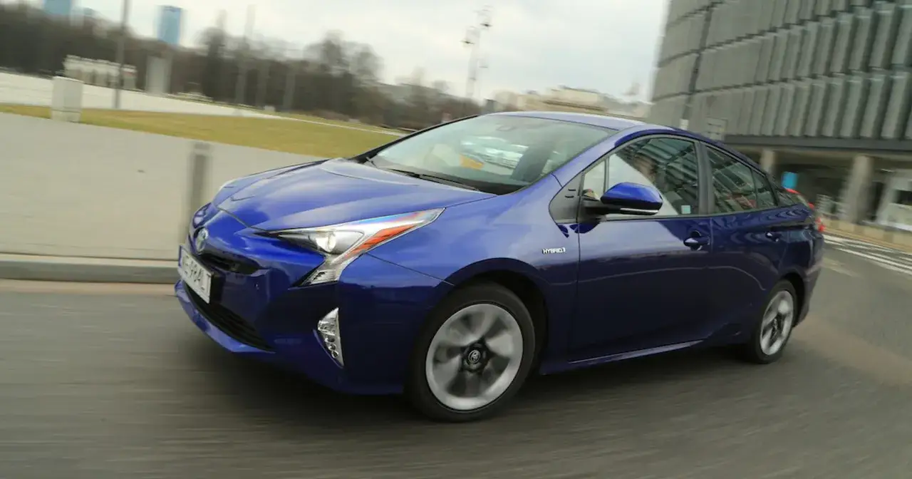 Niebieska Toyota Prius hybryda w ruchu miejskim. Zastanawiasz się, ile pali Toyota Prius hybryda? Ten model jest znany z niskiego spalania.