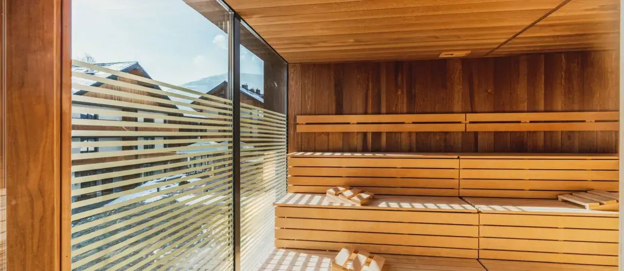 Drewniana sauna z widokiem na ośnieżone góry. Idealne miejsce na relaks w ramach pakietów spa Karpacz.