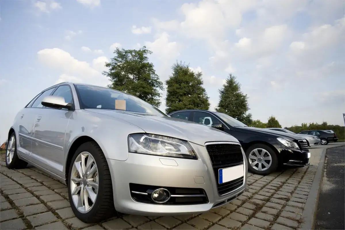 Srebrny i czarny samochód na parkingu. Zastanawiasz się, ile cło za samochód z Niemiec?