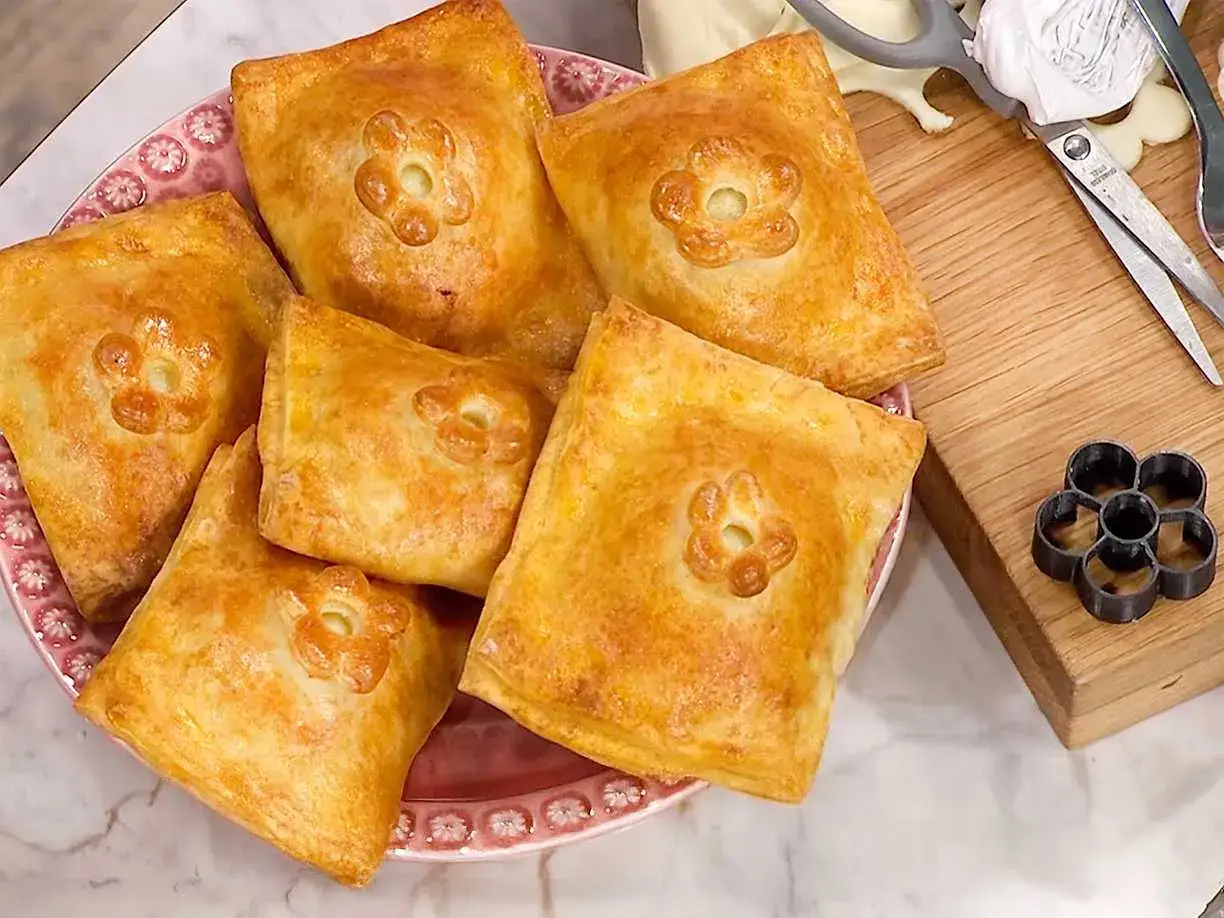 Gyldene piroger med blomstermønster, redo att avnjutas. Ett enkelt pirog recept för hembakat.
