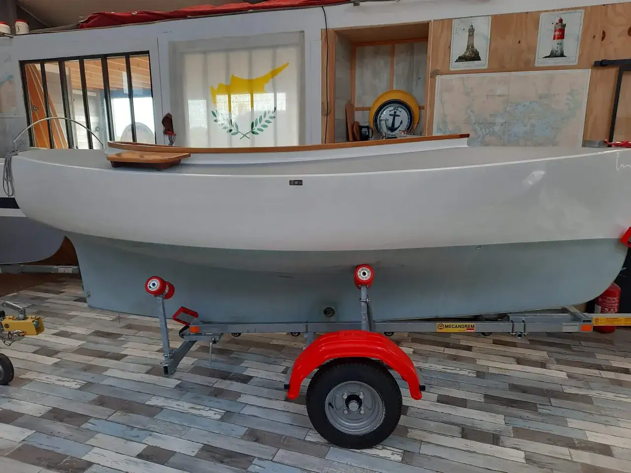 Bateau blanc sur remorque, prêt pour l'aventure. Le drapeau de Chypre flotte discrètement, évoquant des voyages ensoleillés. Un pabouk 360° pour admirer ce navire.