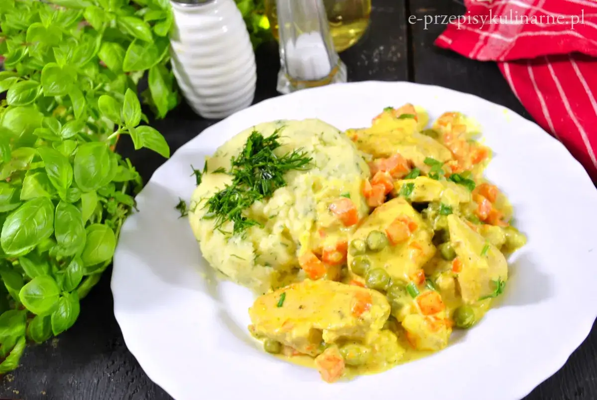 Pyszna potrawka z kurczaka w kremowym sosie z marchewką i groszkiem, podana z puree ziemniaczanym i koperkiem.