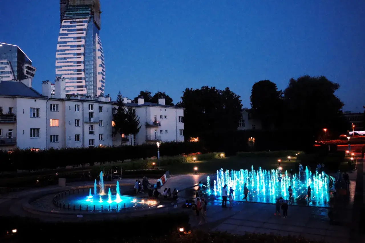 Wieczorne Rzeszów: podświetlana fontanna i nowoczesne budynki. Idealne miejsce, by zobaczyć, co zwiedzić w Rzeszowie.
