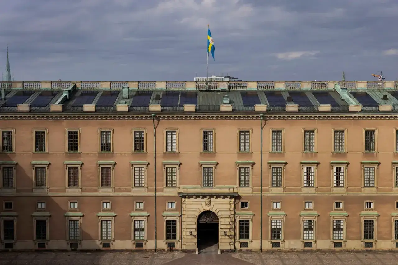 Stockholms slott antal rum är många, här syns en fasad med otaliga fönster under en svensk flagga.