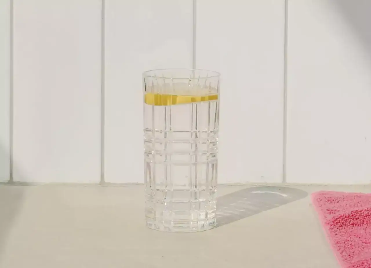 Szklanka z wodą i plasterkiem cytryny, symbol japońskiej diety wodnej. Czystość i prostota.