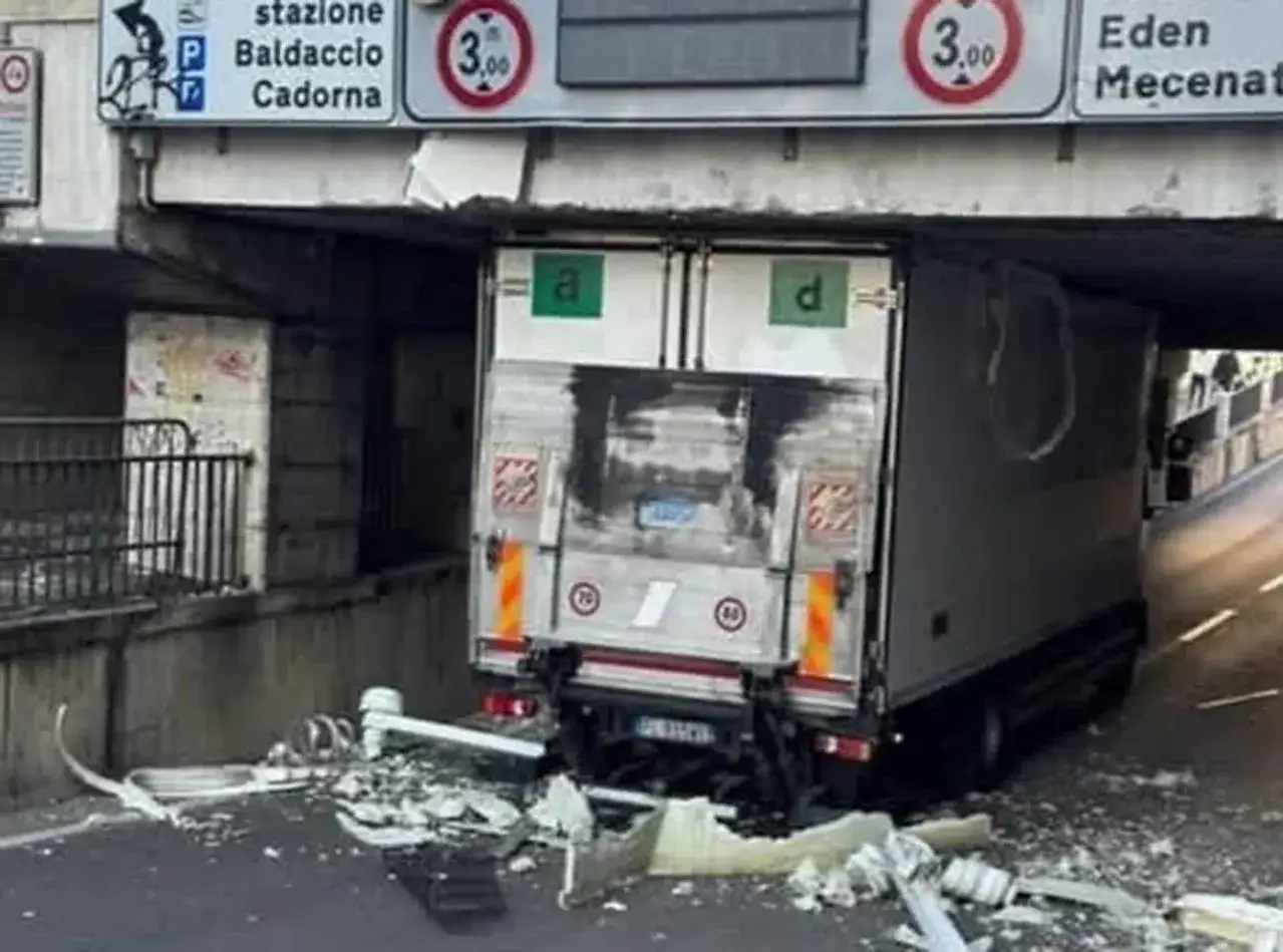 Camion incastrato sotto un ponte, detriti ovunque. Segnale indica altezza massima trasporto su strada: 3 metri.