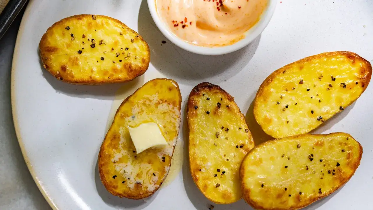 Assiette de pommes de terre au four dor&eacute;es, poivr&eacute;es, avec une noix de beurre fondant et une sauce cr&eacute;meuse. Un d&eacute;lice !