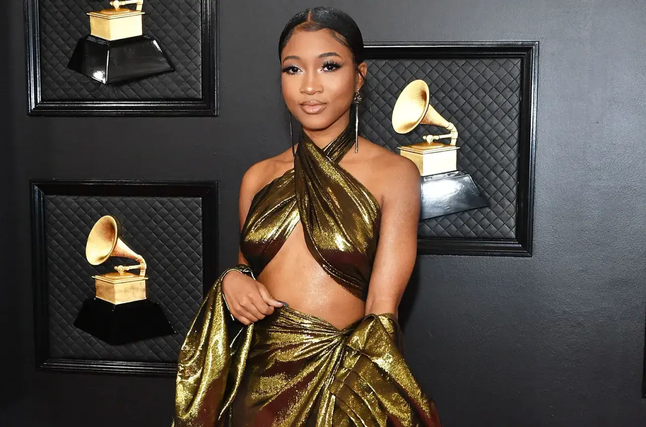 Nija Charles shines in a golden gown at the Grammys, a true star among the iconic gramophone awards.