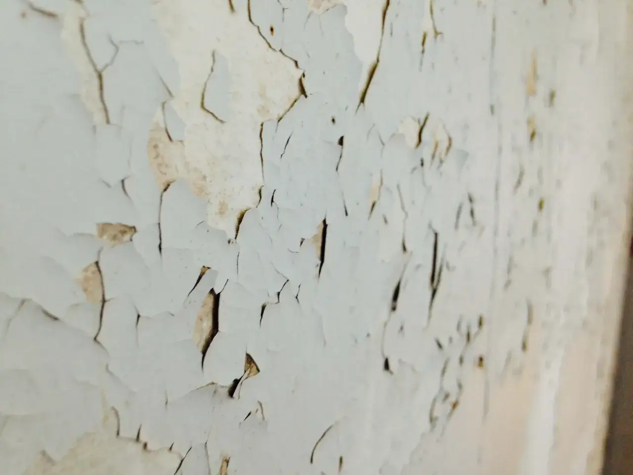 Peinture &eacute;caill&eacute;e, un mur ancien qui demande quelle peinture pour recouvrir peinture au plomb. La surface est craquel&eacute;e, r&eacute;v&eacute;lant des couches anciennes.
