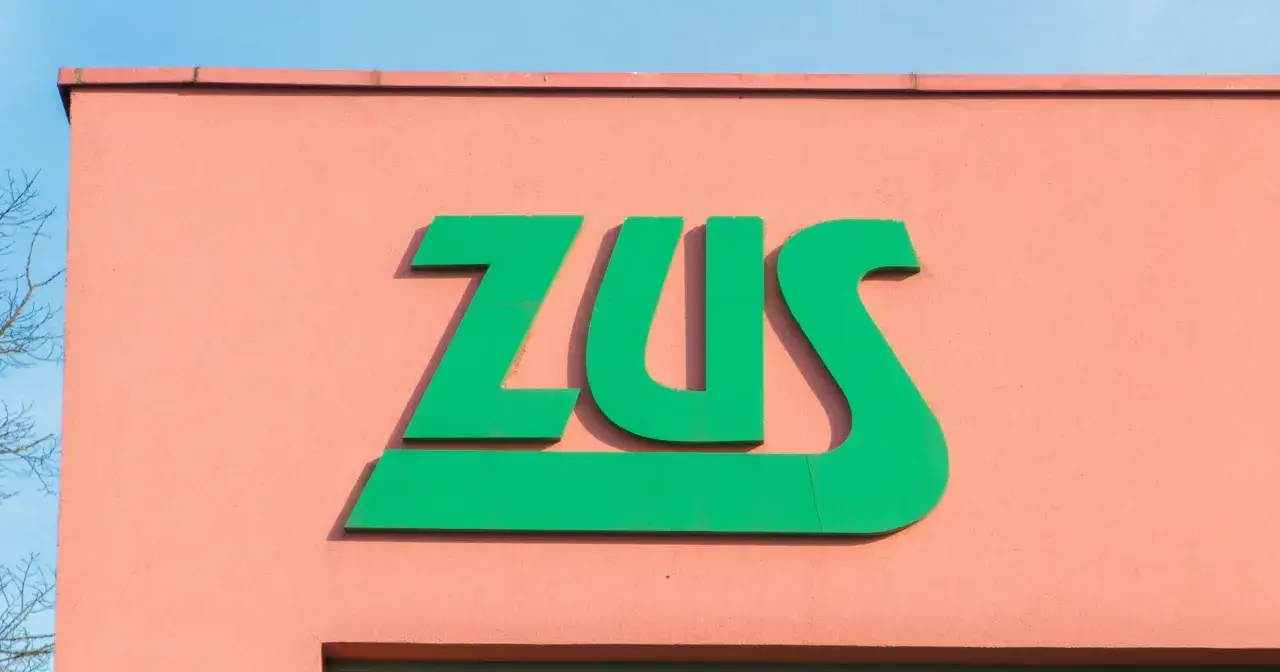 Zielone logo ZUS na r&oacute;żowej ścianie. Zastanawiasz się, ile można być na zwolnieniu lekarskim od psychiatry?