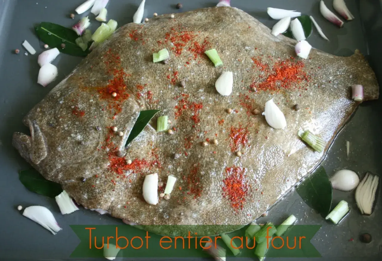 Un turbot entier est pr&ecirc;t &agrave; &ecirc;tre r&ocirc;ti au four, assaisonn&eacute; de paprika, d'ail, d'oignons et de grains de poivre.