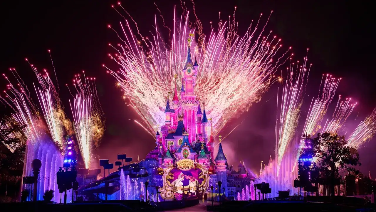 Castillo de ensueño iluminado por fuegos artificiales rosas y morados, como si fuera un sueño de fuegos artificiales.