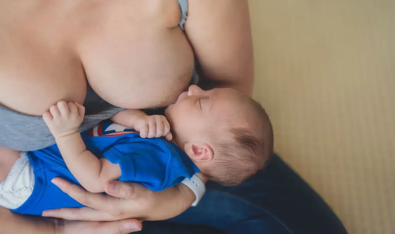 Ein Baby trinkt friedlich an der Brust. Die Frage 