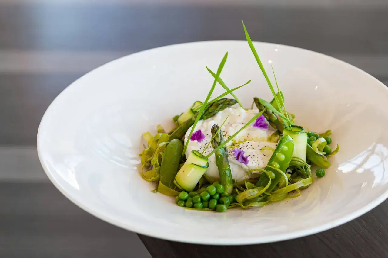 En lyxig sallad till buff&eacute; med kr&auml;mig ost, sparris, socker&auml;rtor och gurka, garnerad med &ouml;rter och blommor.