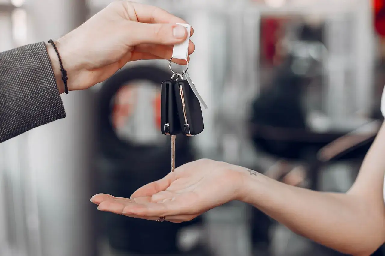 Une main tend des cl&eacute;s de voiture &agrave; une autre. Id&eacute;al pour une assurance conducteur occasionnel.