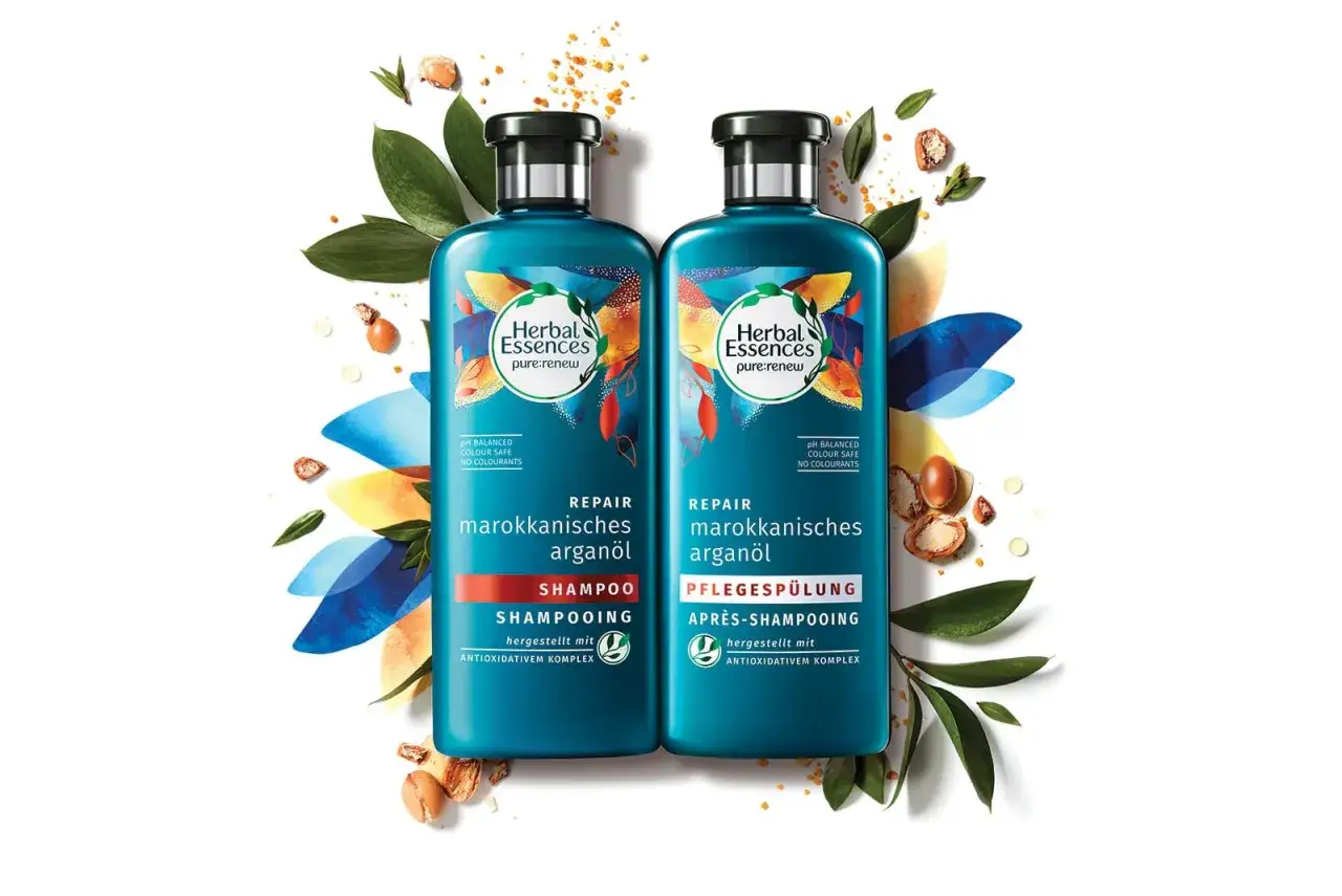 Zwei Flaschen Herbal Essences Shampoo mit marokkanischem Argan&ouml;l, tierversuchsfrei, umgeben von Bl&auml;ttern und Arganfr&uuml;chten.