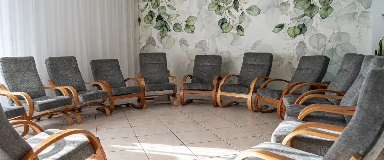 Krzesła ustawione w kręgu w sali terapeutycznej ośrodka terapii uzależnień i depresji.