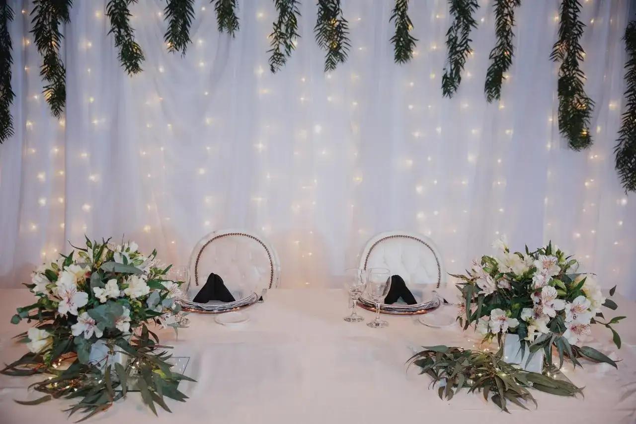 Mesa de bodas con flores y luces, ideal para planificar como hacer una boda econ&oacute;mica y rom&aacute;ntica.