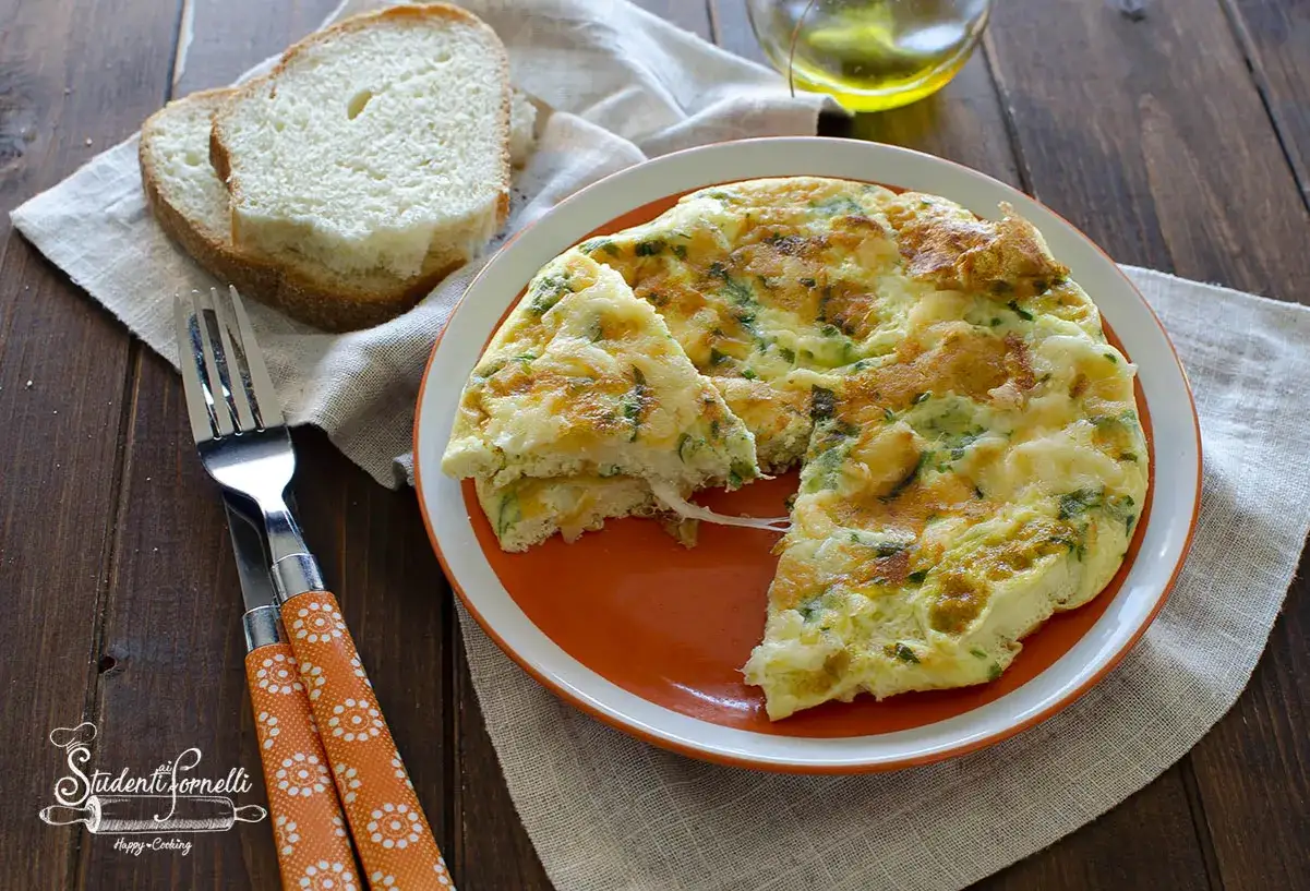 Frittata di albumi soffice e dorata, con erbe aromatiche e formaggio filante, servita con fette di pane tostato.
