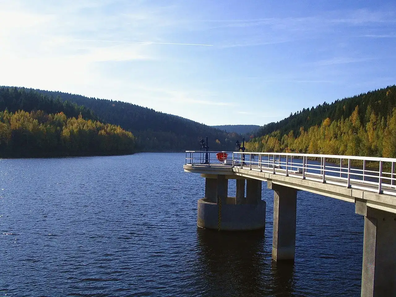 Die Talsperre Falkenstein mit ihrem Steg ragt in den ruhigen See. Umgeben von herbstlich gef&auml;rbten W&auml;ldern, bietet sie einen malerischen Anblick.