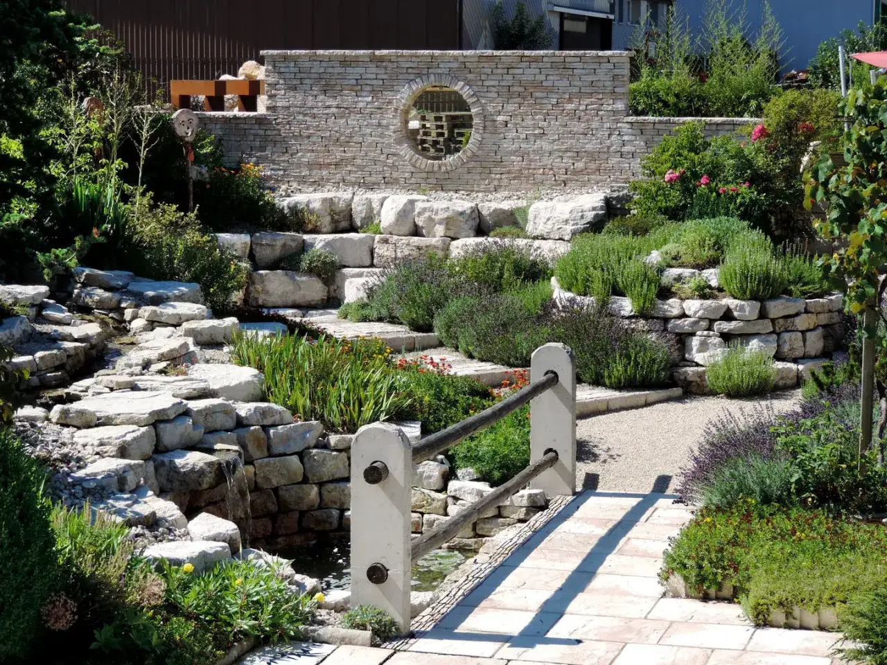 Un angolo di pace tra giardini moderni, con rocce, acqua che scorre e profumate erbe aromatiche.