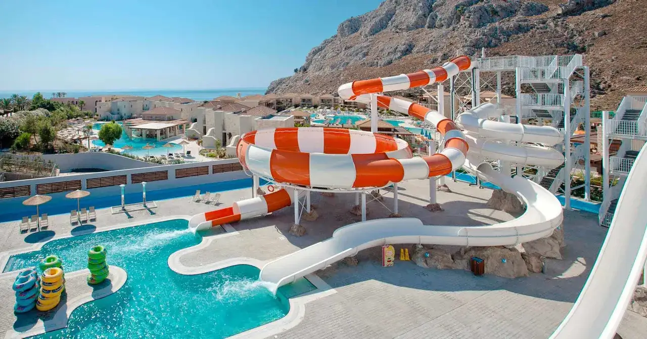 Vattenrutschkanor vid ett aegean park rhodos. Solstolar och parasoller vid poolen.