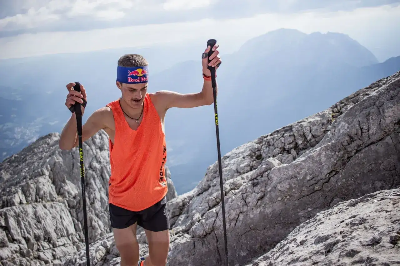 Anton Palzer bezwingt den Watzmann, gest&uuml;tzt auf St&ouml;cke, mit einem roten Red Bull Stirnband.