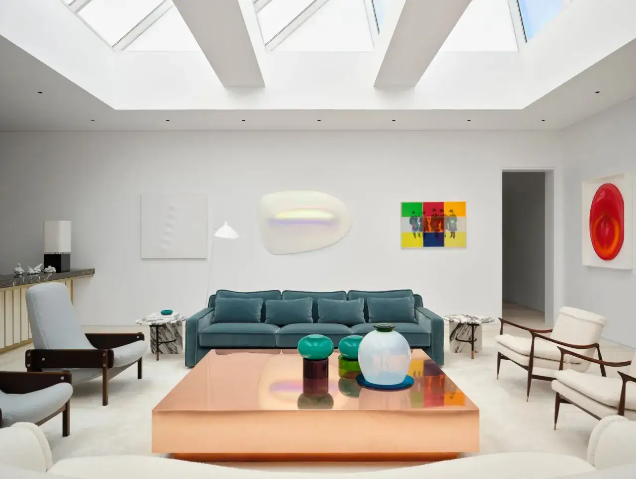 Un elegante divano in mezzo alla stanza, circondato da opere d'arte moderne e mobili di design.