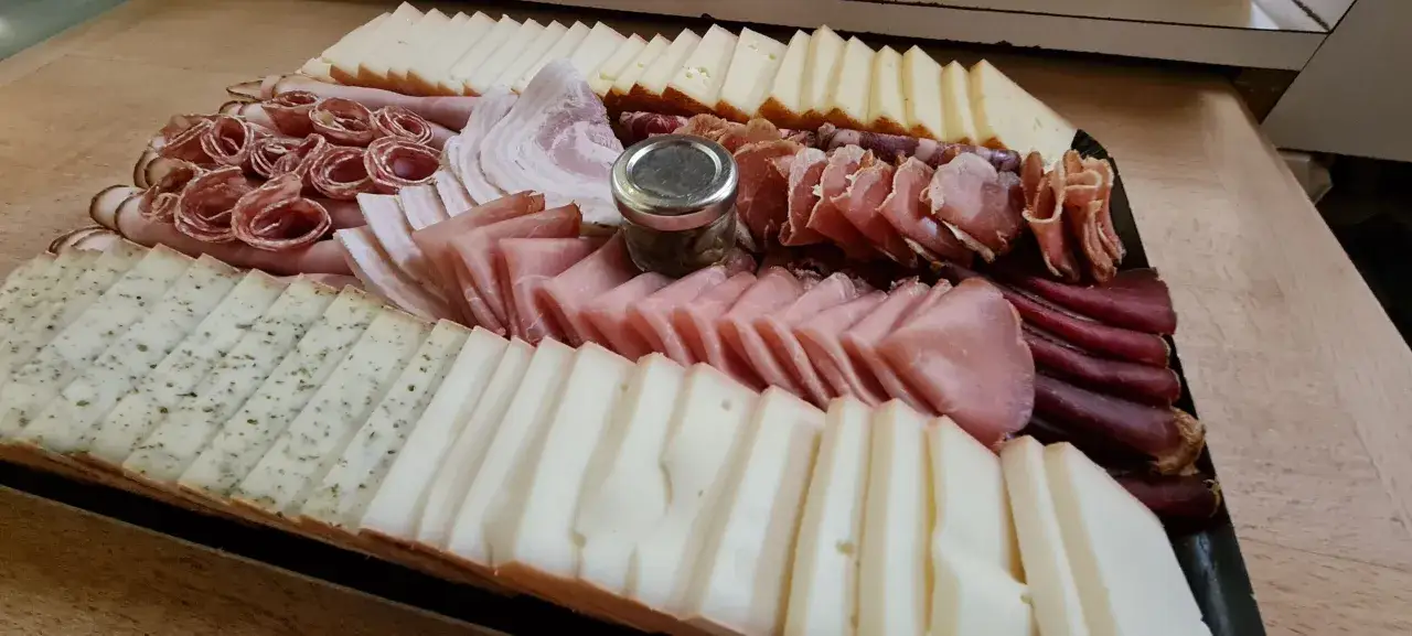 Plateau généreux de fromages et charcuteries, parfait pour une soirée raclette entre amis.
