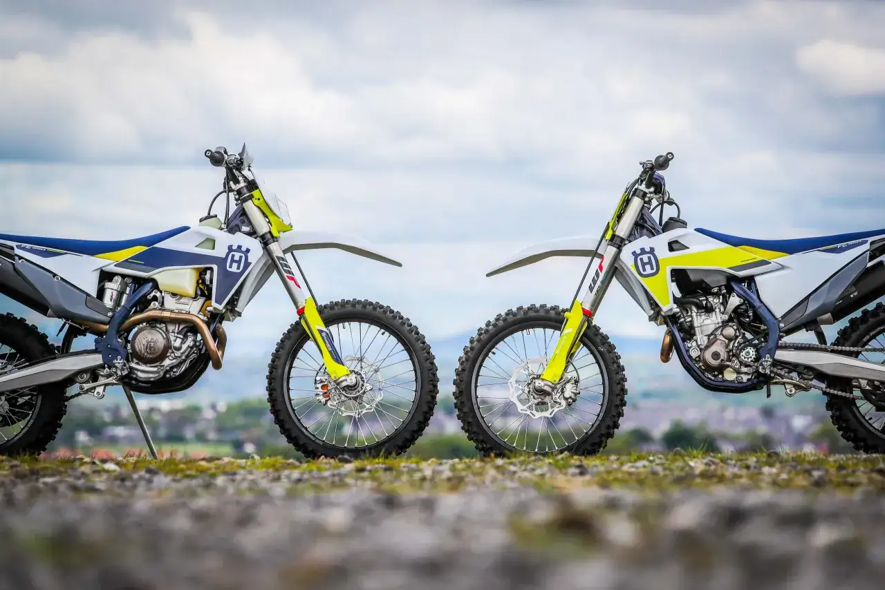 Dos motos Husqvarna, una para enduro y otra para motocross, listas para la aventura. La diferencia entre enduro y motocross se ve en su diseño.