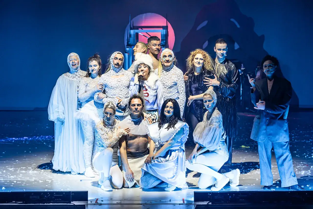 Grupa aktorów w fantazyjnych strojach na scenie. Warto zobaczyć te polecane spektakle Warszawa!