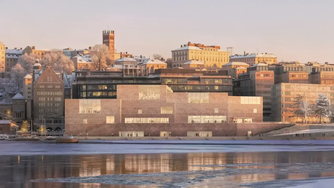 Vintervy &ouml;ver Stockholm med det nya Nobel Prize Museum. Byggnaden i tegel har stora f&ouml;nster och speglar sig i det isiga vattnet.
