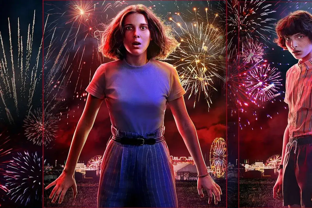 Nastka z Stranger Things stoi na tle fajerwerków i wesołego miasteczka.