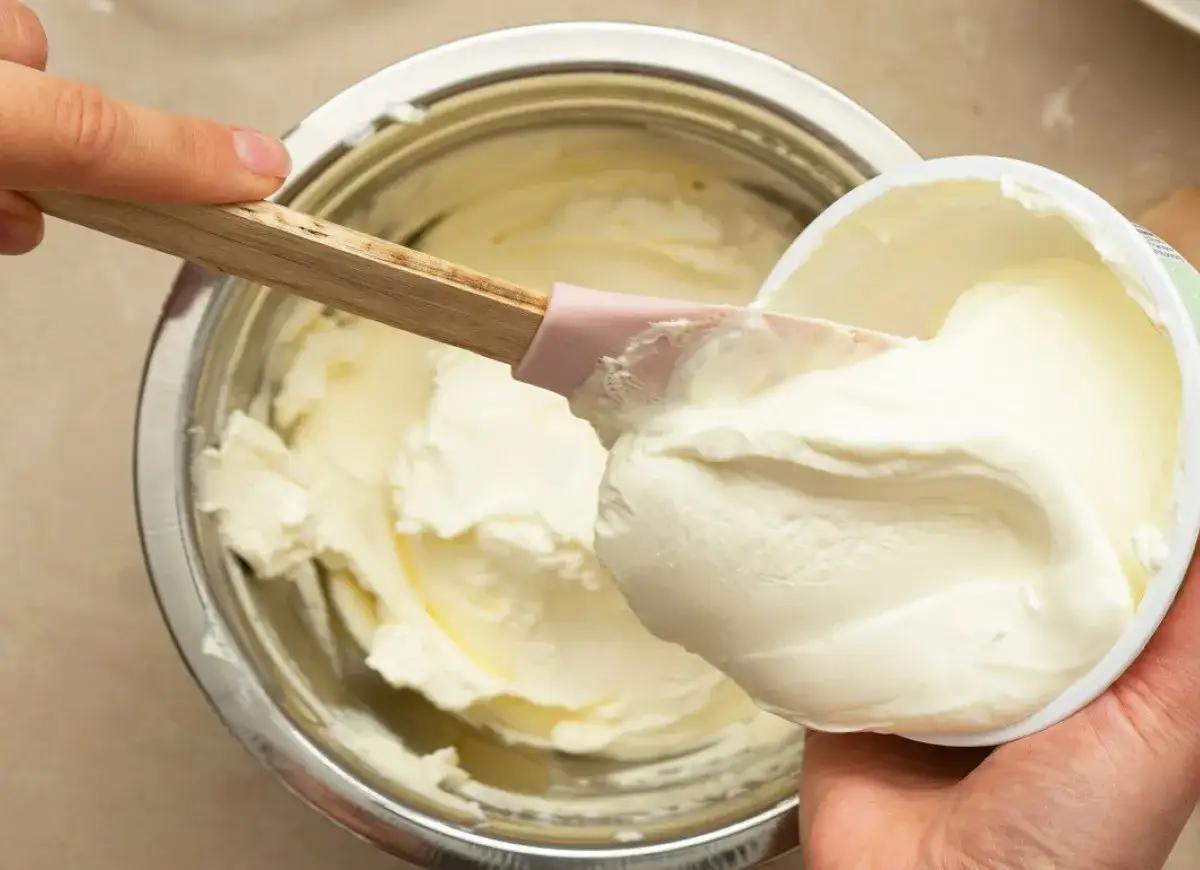 Łyżka z mascarpone w misce z serkiem homogenizowanym. Decyzja, co wybrać do deseru, jest trudna!