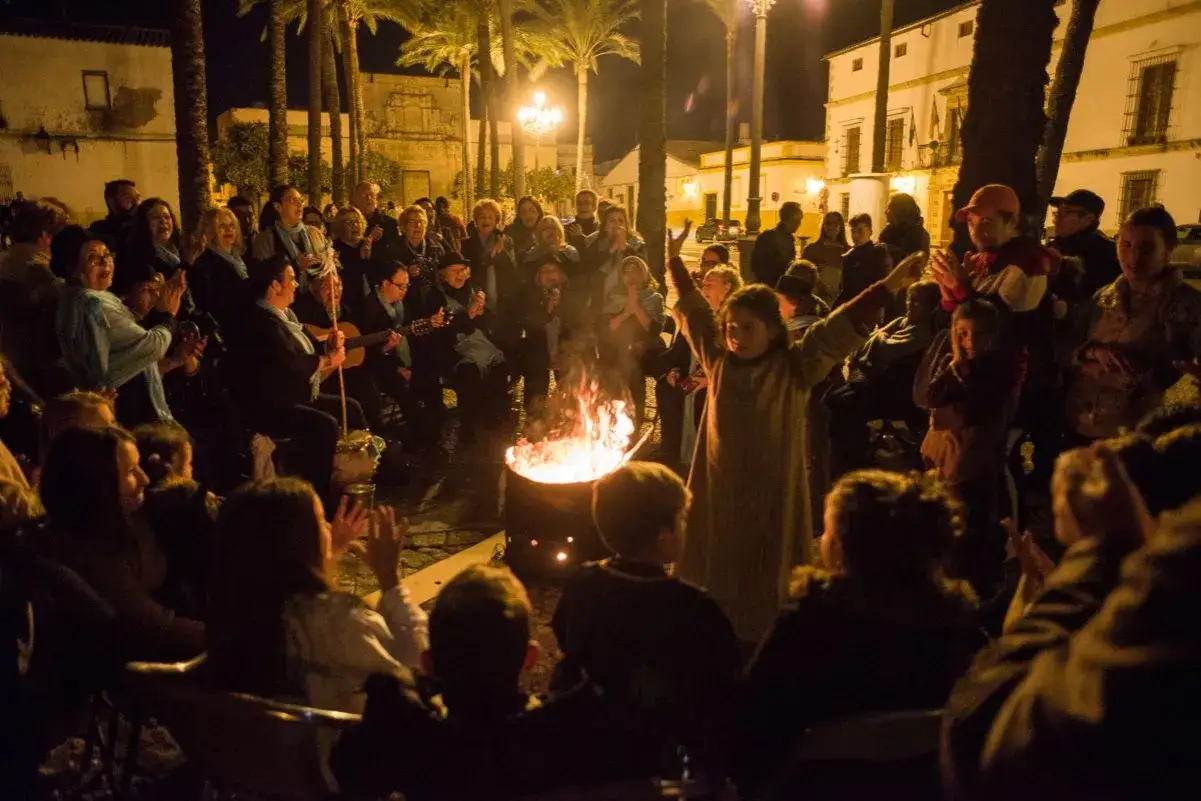 Noche de villancicos flamencos jerezanos junto a una hoguera. Gente reunida, cantando y tocando la guitarra.