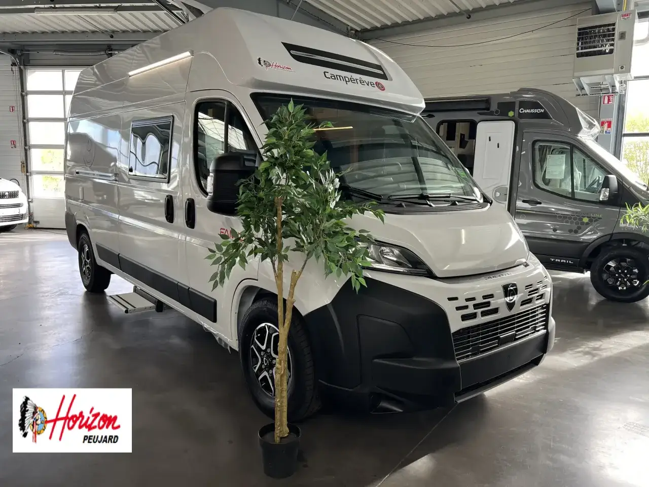 Avis Fiat Ducato 2.2 Multijet 140 CV : ce camping-car blanc Campérêve est prêt pour l'aventure. Un autre, gris Chausson, est garé derrière.