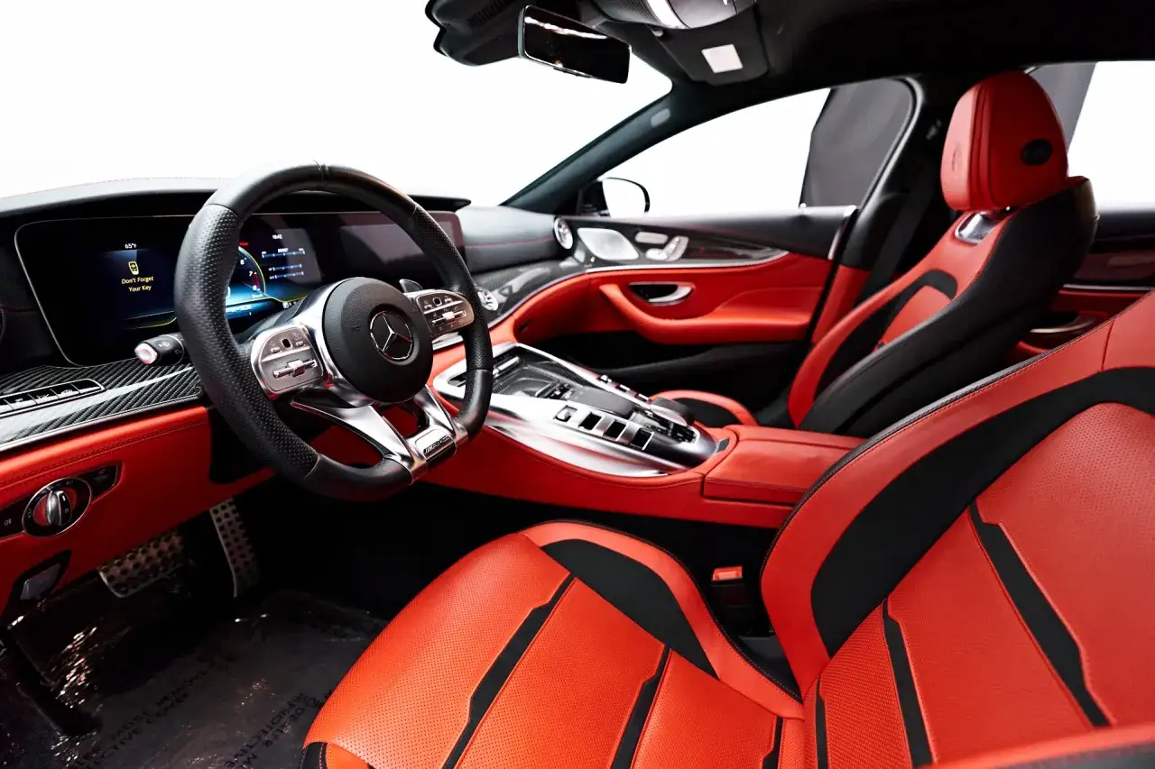 Wnętrze GT63S z czerwono-czarną skórzaną tapicerką, sportową kierownicą i nowoczesnym panelem cyfrowym.