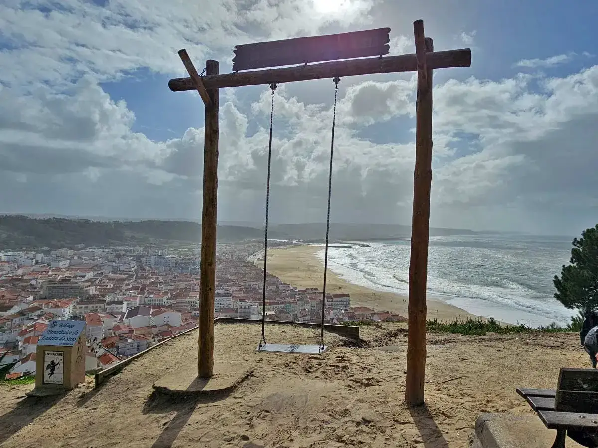 Schaukel mit Blick auf die Stadt und den Strand von Nazaré. Hier liegt Nazaré, ein malerischer Küstenort in Portugal.