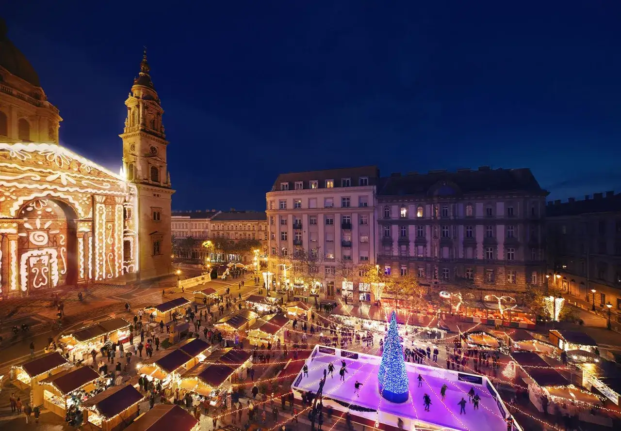 Magiczny budapeszt jarmark bożonarodzeniowy. Tłumy ludzi na lodowisku i przy straganach, oświetlona choinka i bazylika.